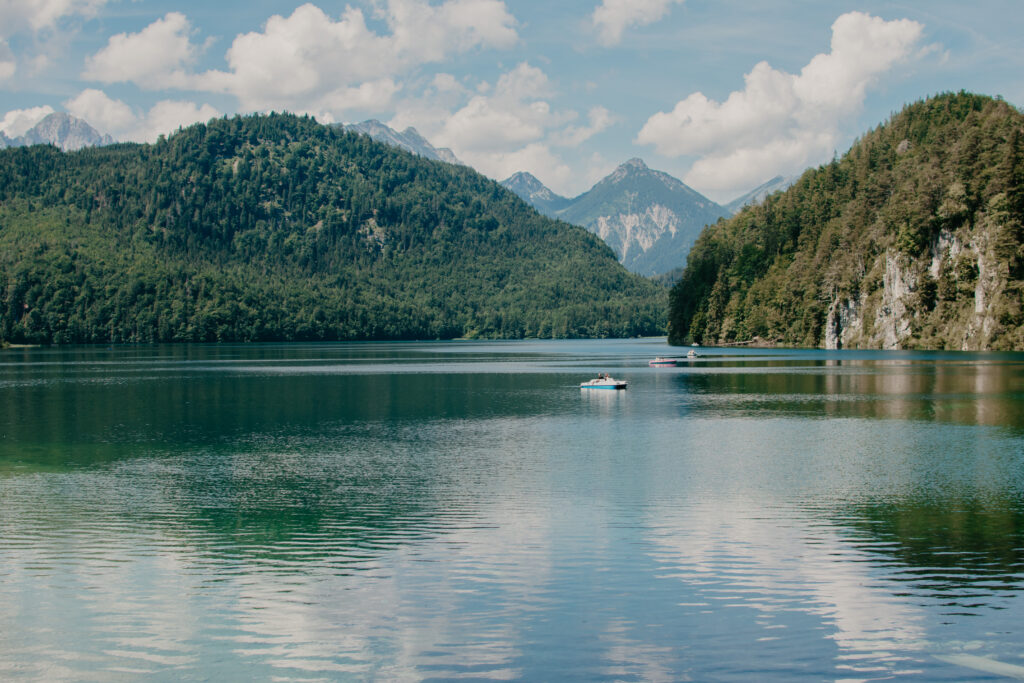 Photo of Eibsee Lake with a few people paddle boarding and the mountains in the background.